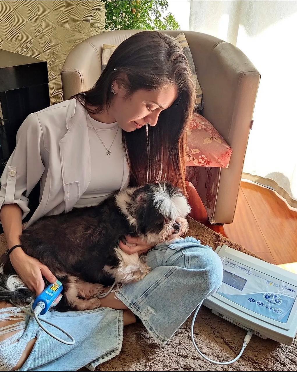 Dra. Mariana realizando atendimento de reabilitação com um cão